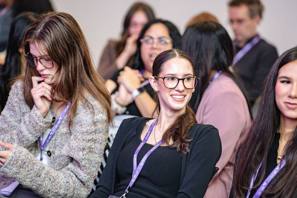 A smiling attendee seated in the audience