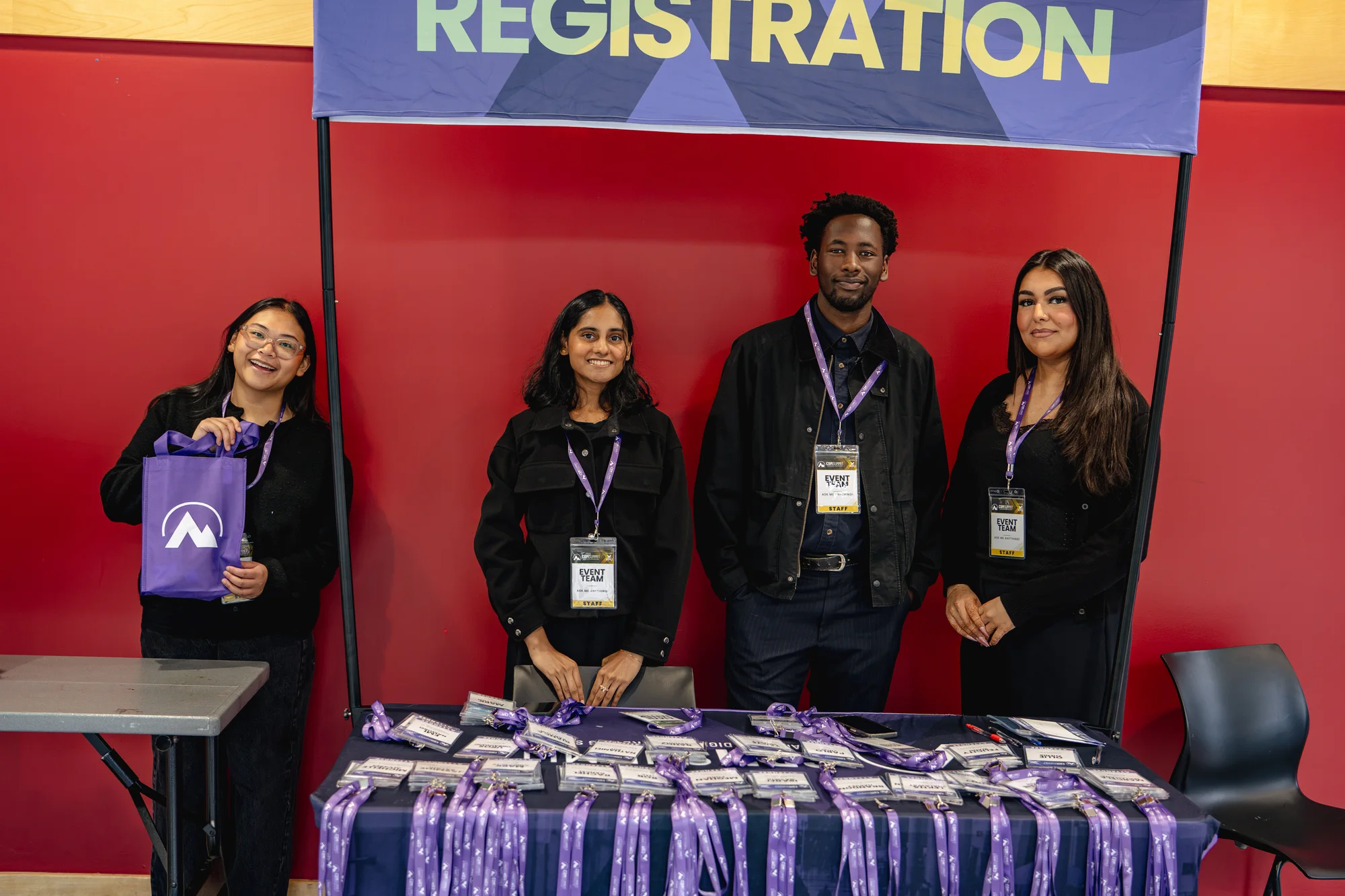 Four registration team members behind the badge table at CDM Summit Fraser Valley 2026
