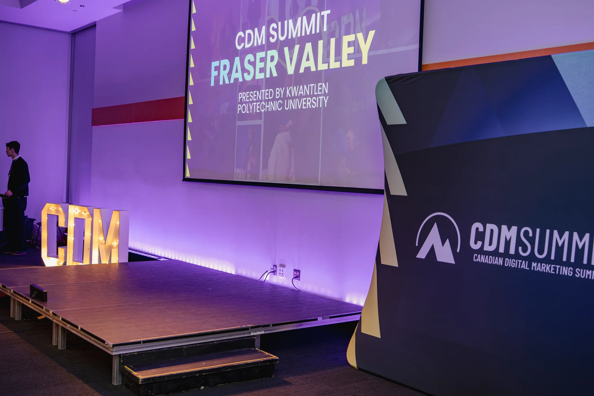 Wide view of the stage with illuminated CDM letters at CDM Summit Fraser Valley 2026