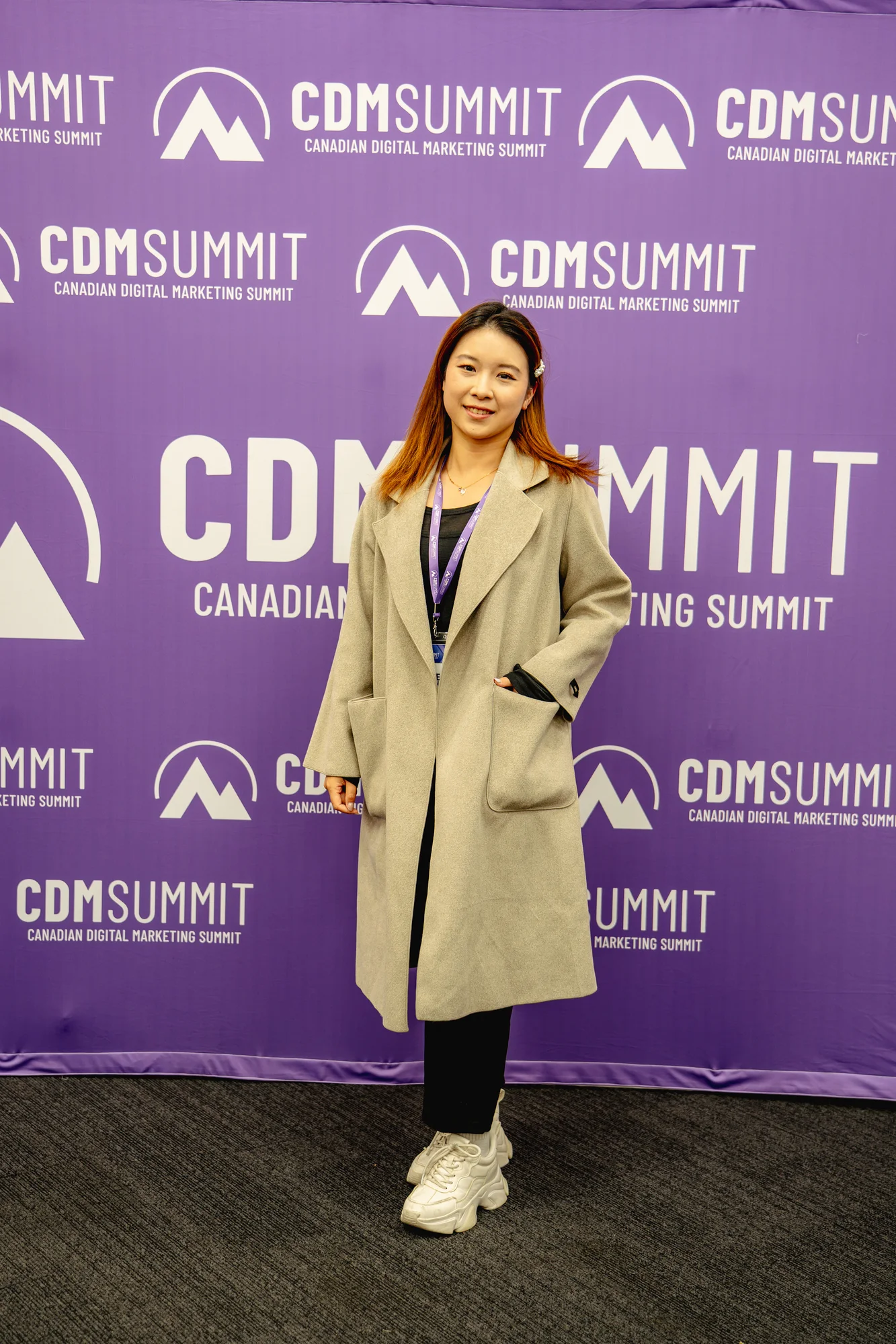 An attendee posing at the purple CDM Summit backdrop at CDM Summit Fraser Valley 2026