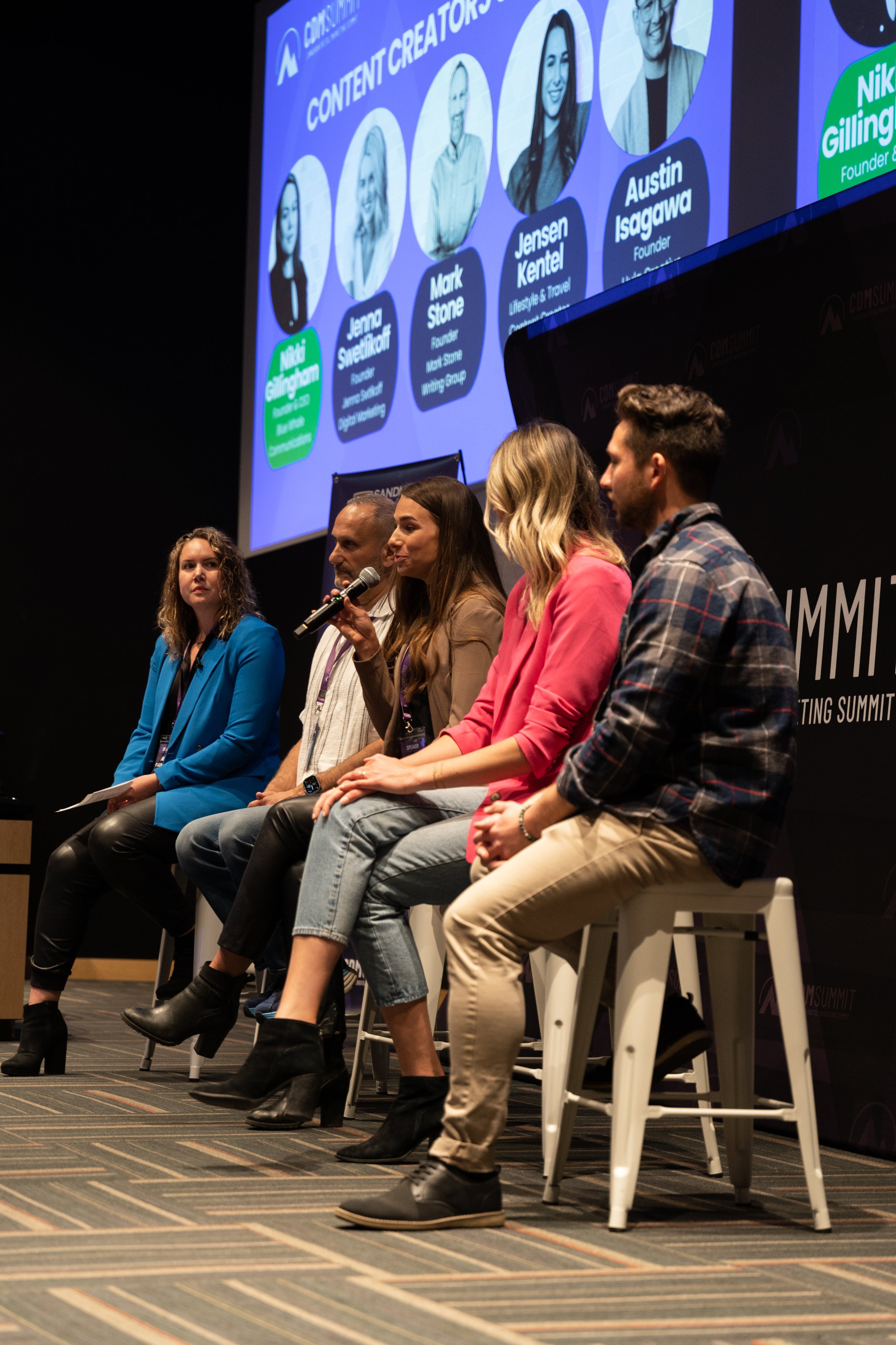 A panel speaking on stage beneath the Content Creators screen